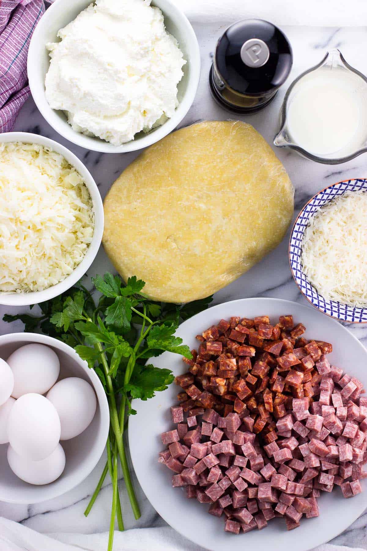 Recipe ingredients in separate containers on a marble board.