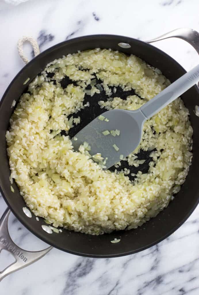 Onion and rice in the pan having absorbed the wine.