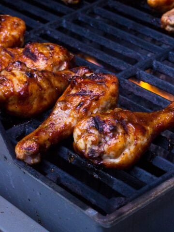 Basted chicken drumsticks on the grill.