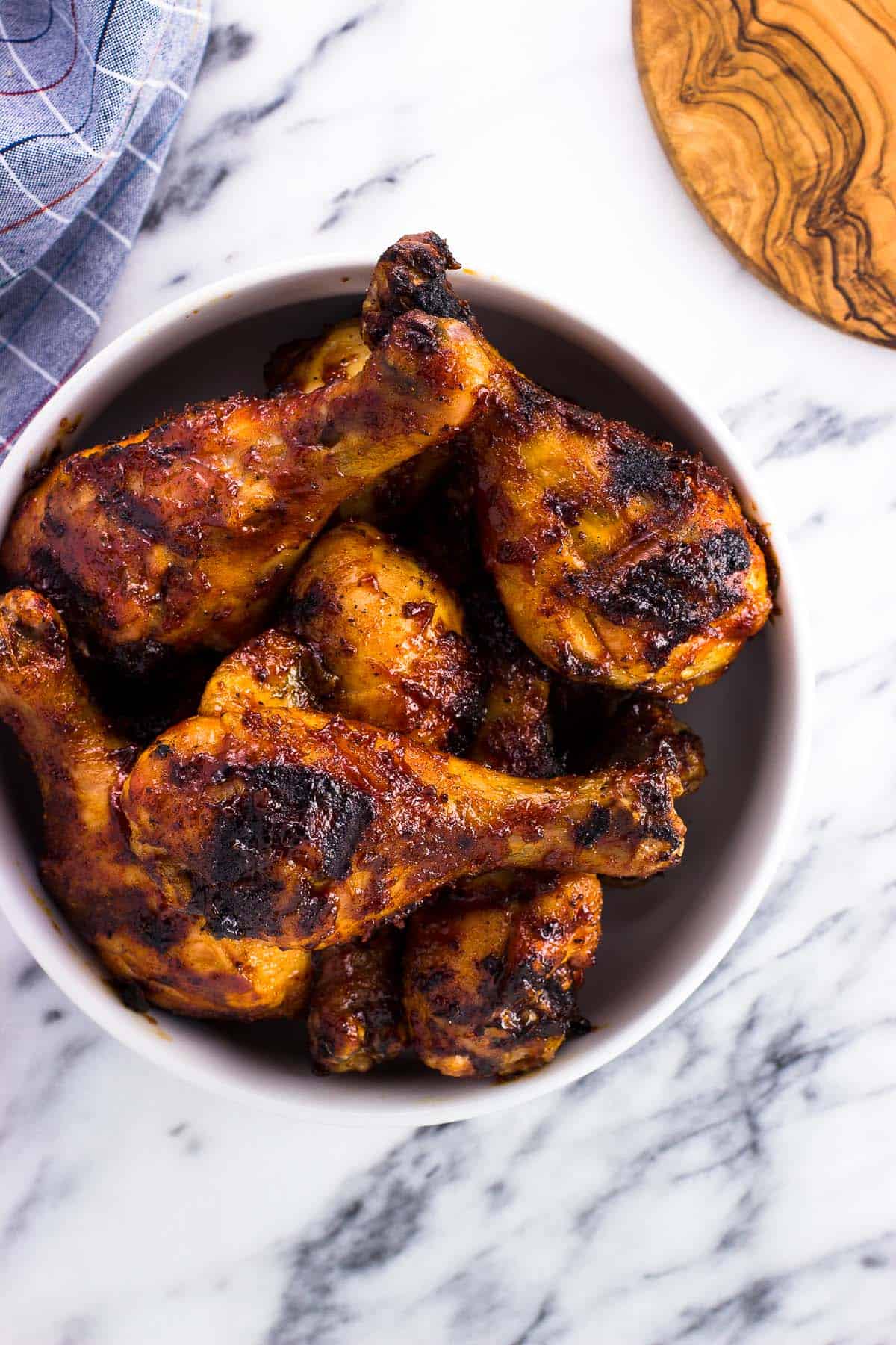 A serving bowl filled with chicken drumsticks.