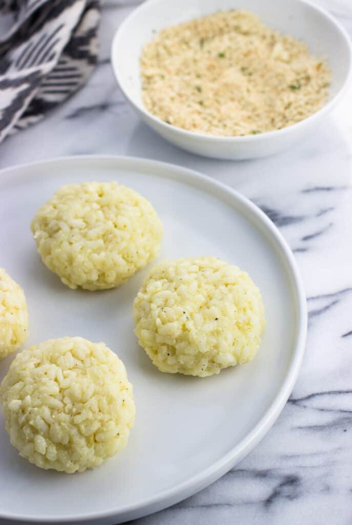 Leftover risotto formed into patties on a plate.