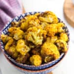 Seasoned and air fried cauliflower florets in a serving bowl.
