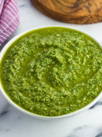 Creamy arugula pesto sauce in a bowl.