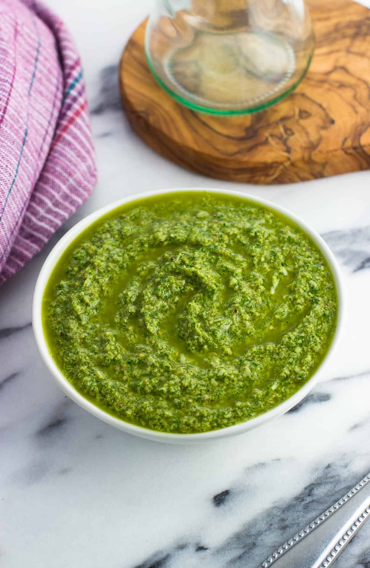 Arugula pesto sauce in a small ceramic bowl.