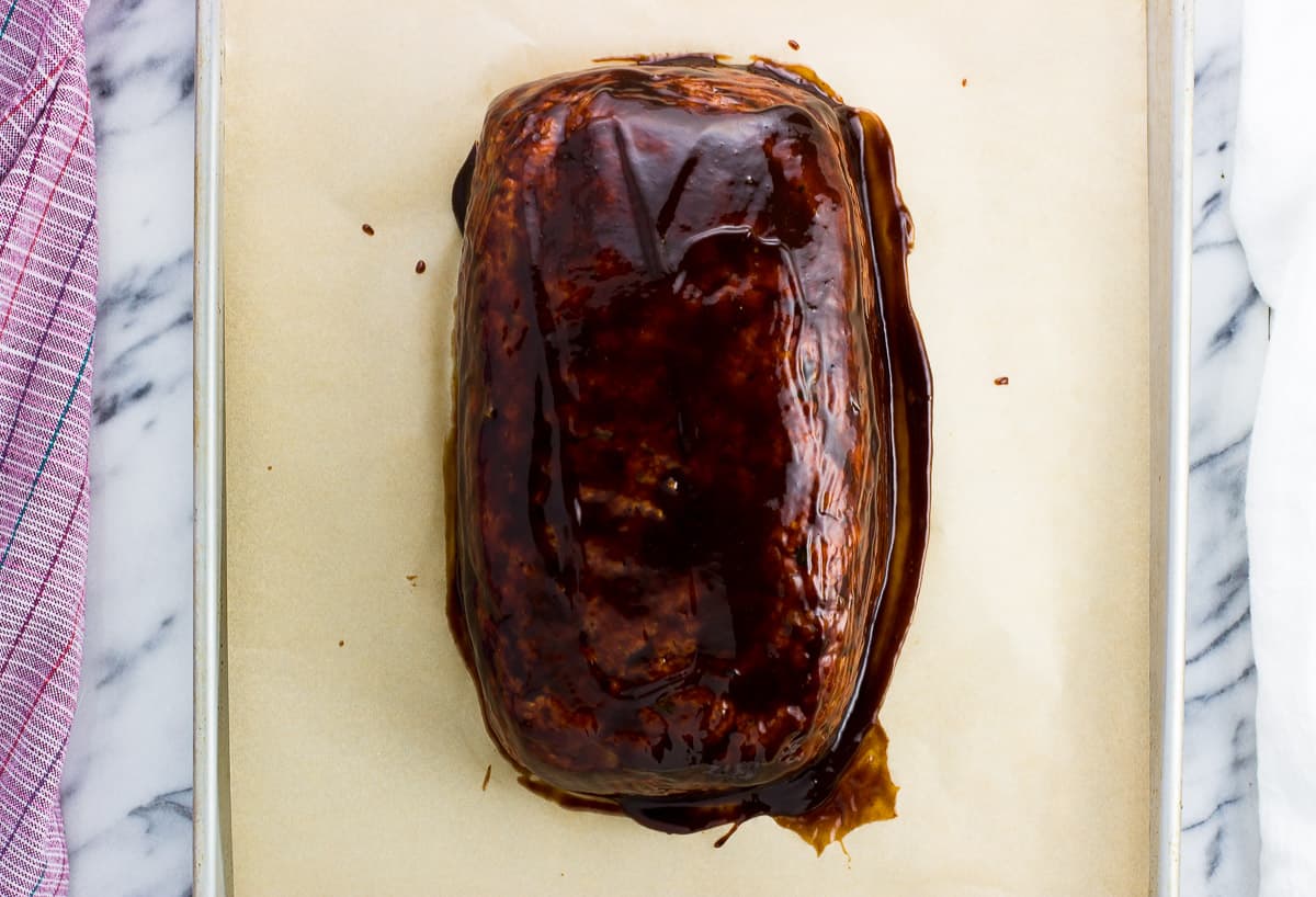 Glazed meatloaf on a sheet pan before baking.