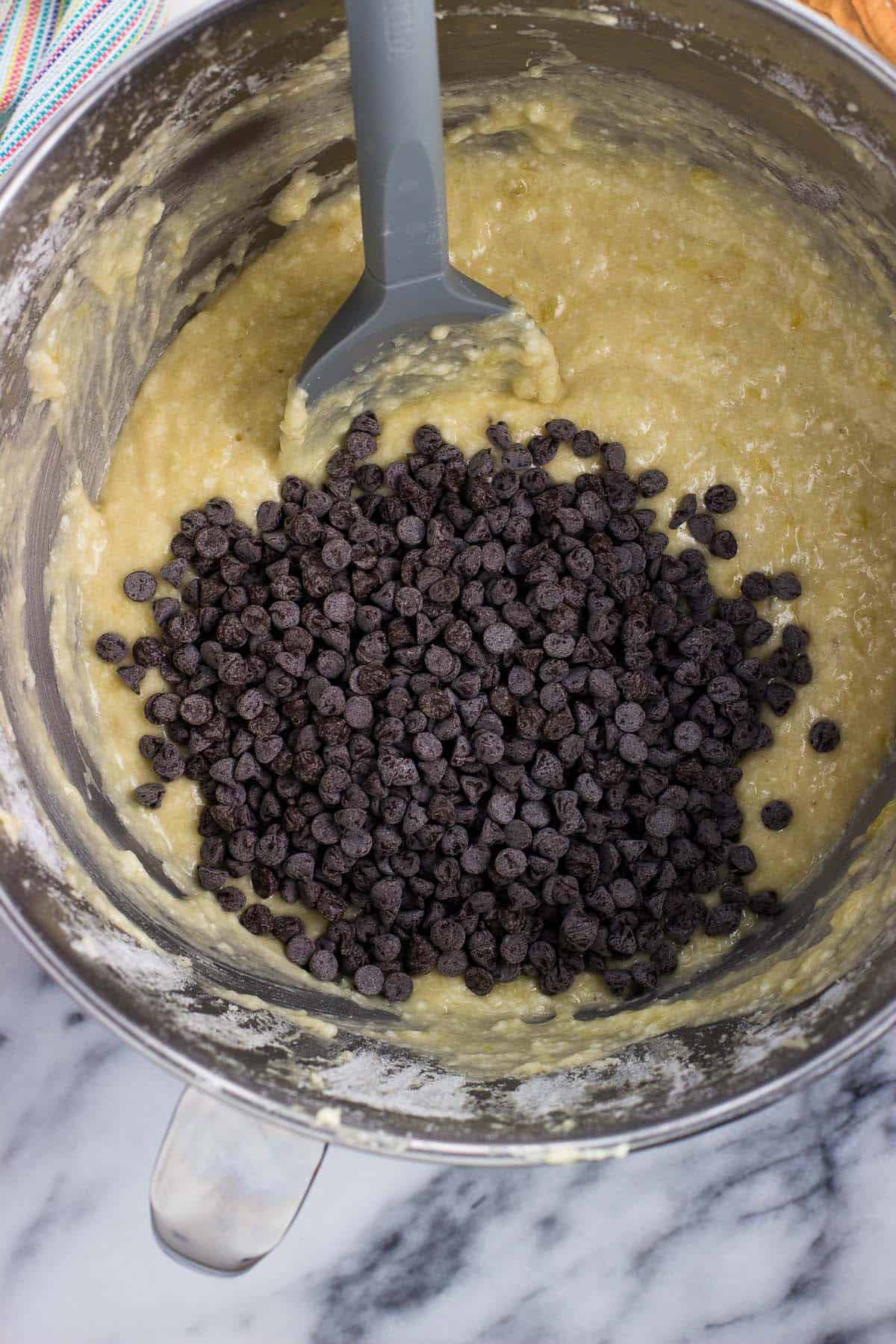 Mini chocolate chips poured into the bowl of batter.