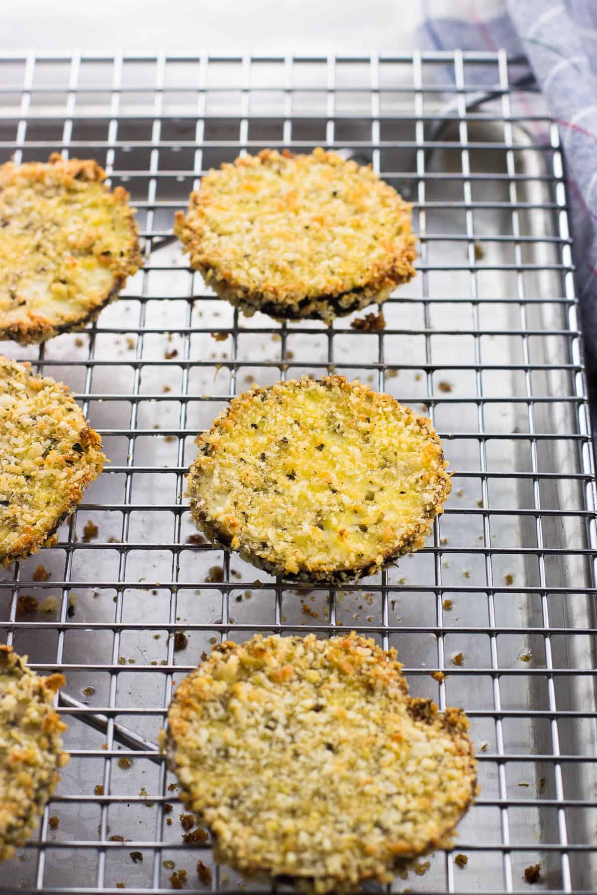 Baked eggplant rounds on a wire rack.