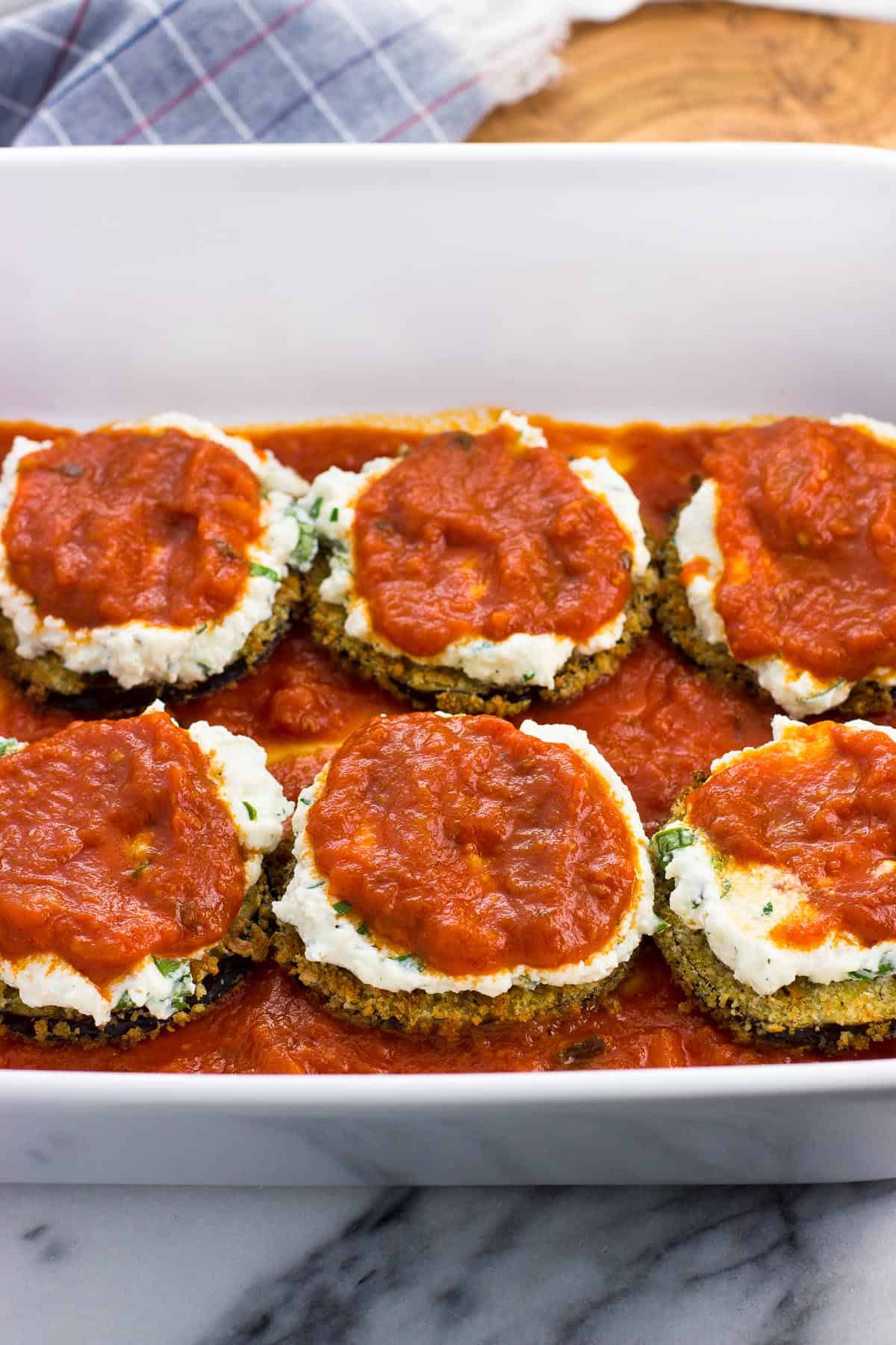 Sauce spread on top of the ricotta on the eggplant rounds.