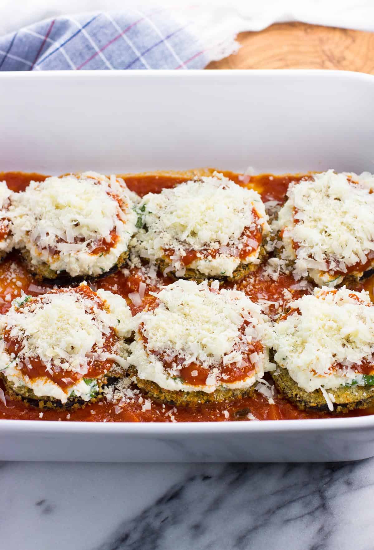 Cheese on top of the sauce and ricotta on the eggplant rounds.