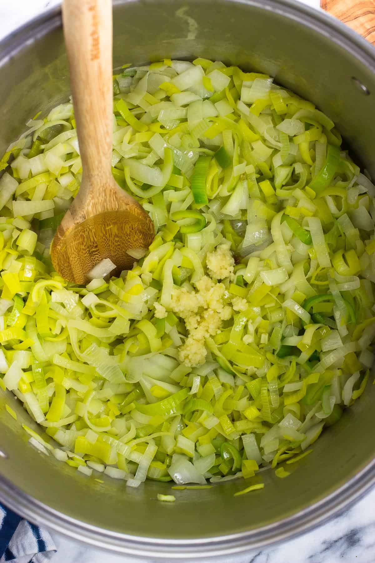 Pressed garlic added to the pot of sauteed leeks and onions.