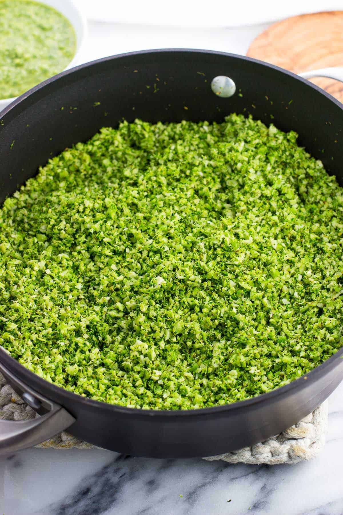 Riced broccoli in a pan after being sauteed.