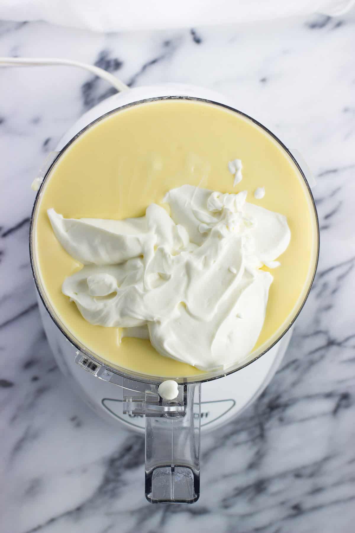 Sour cream added to the cheesecake mixture in the food processor.