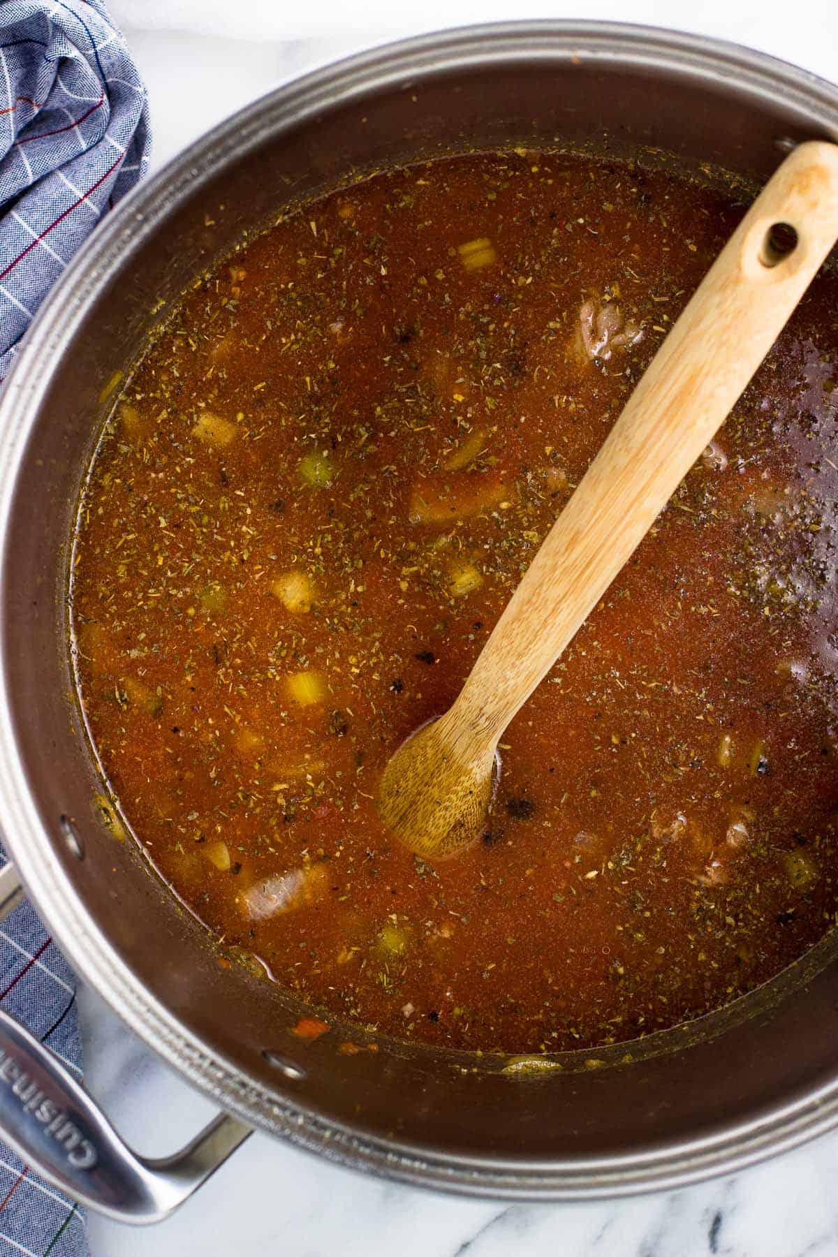 Crushed and diced tomatoes poured into the pot of soup.