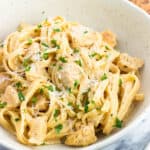 A plate of buffalo chicken alfredo pasta garnished with parsley.