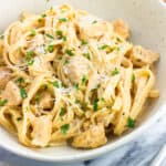 A plate of buffalo chicken alfredo pasta garnished with parsley.