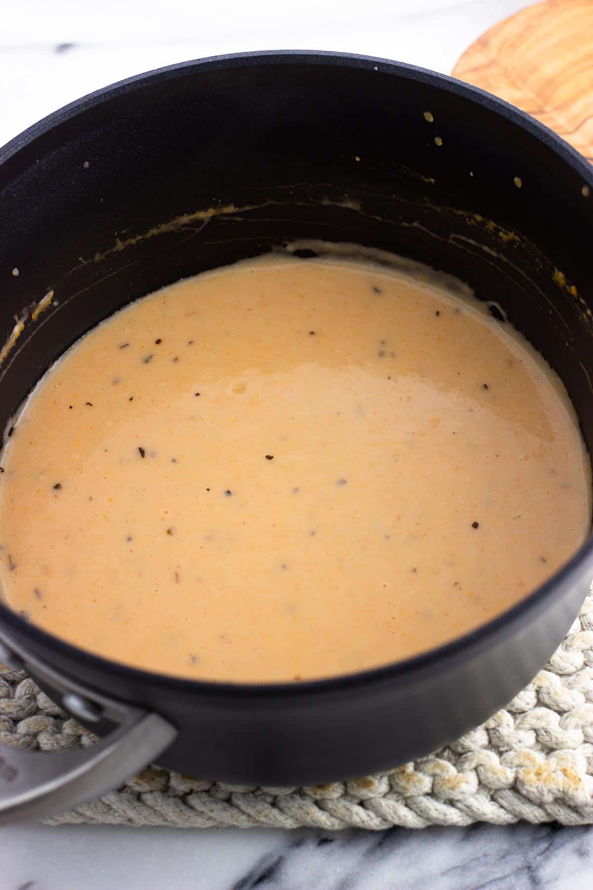 Buffalo alfredo sauce in a saucepan.