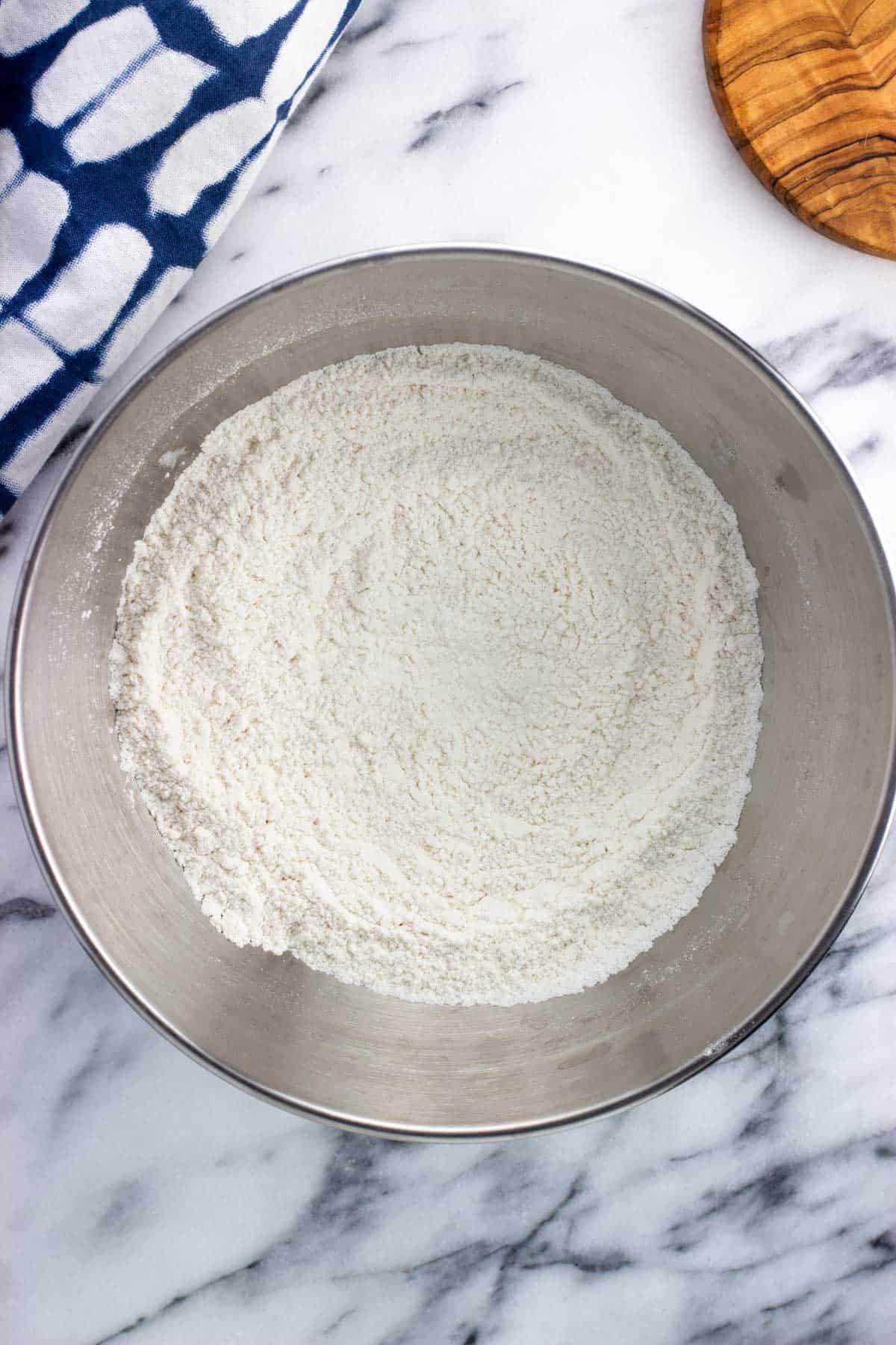 Dry ingredients combined in a metal mixing bowl.