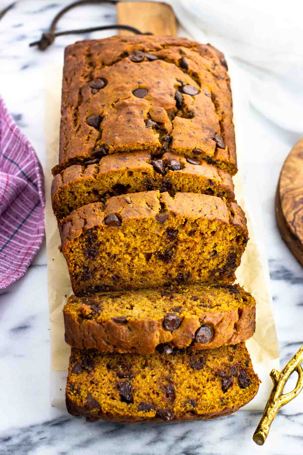 A loaf of pumpkin banana bread half cut into slices.