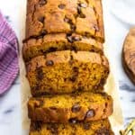 A loaf of pumpkin banana bread half cut into slices.