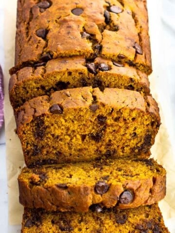 A loaf of pumpkin banana bread half cut into slices.