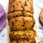 A loaf of pumpkin banana bread half cut into slices.