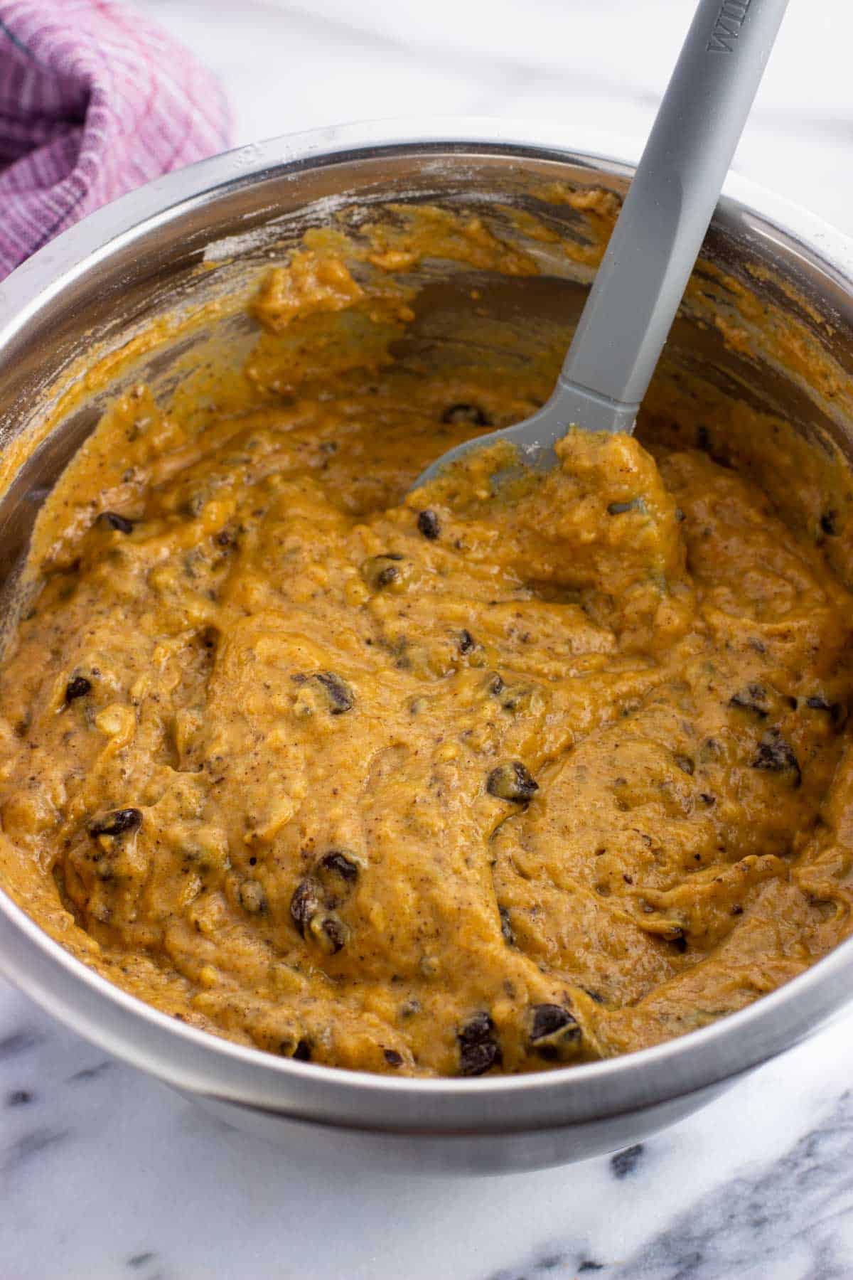 Chocolate chips stirred into the batter in a mixing bowl.