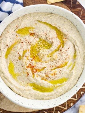 A bowl of hummus drizzled with olive oil.