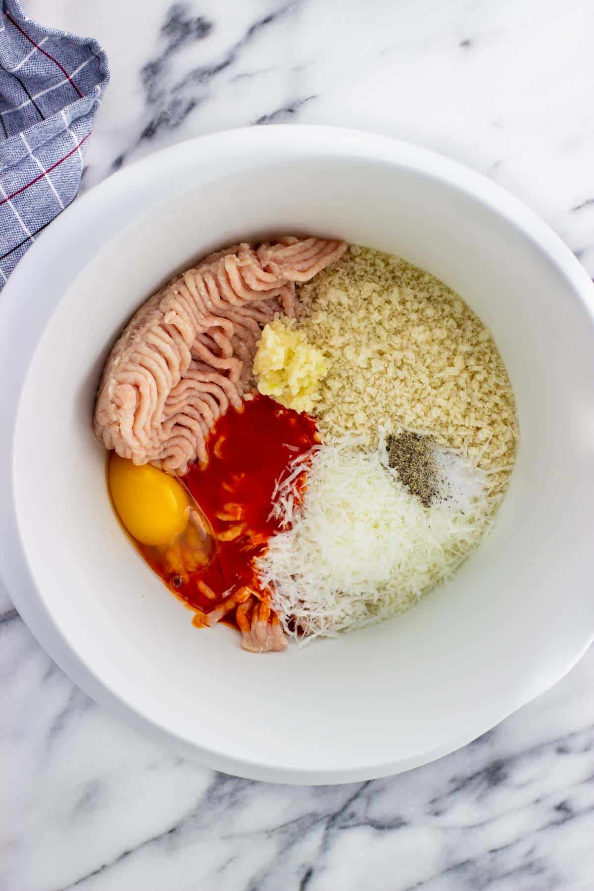 All meatball ingredients added to a mixing bowl before combining.