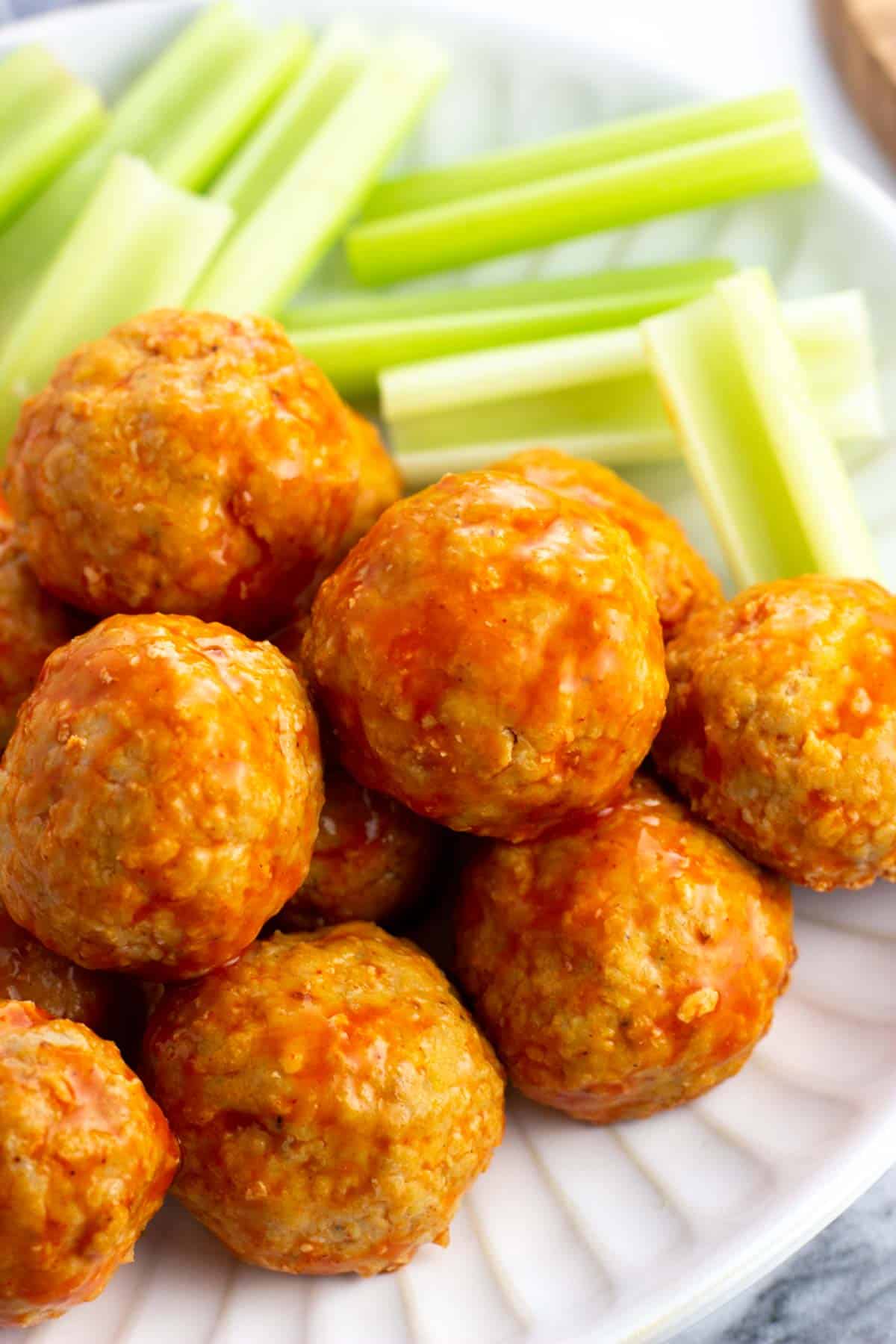 A close-up of a pile of saucy buffalo chicken meatballs.