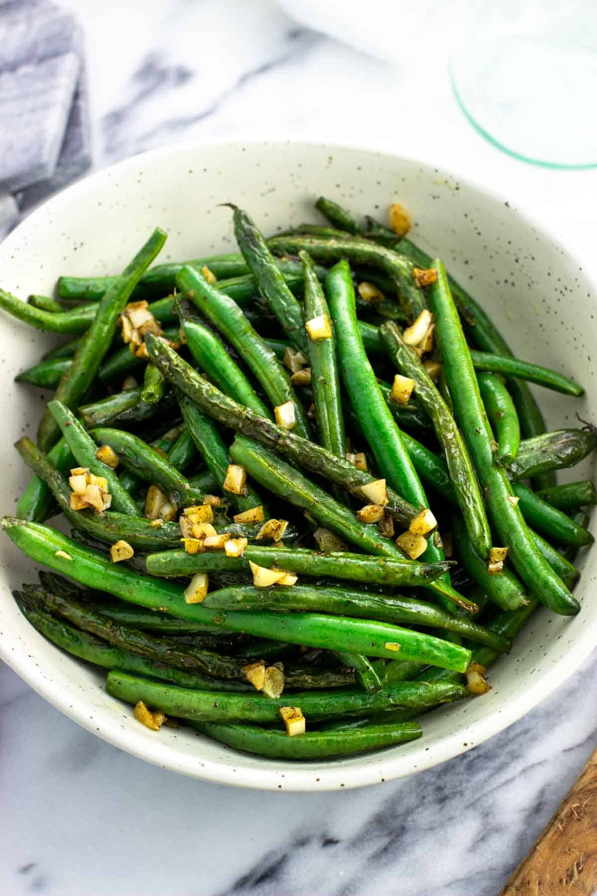 A serving bowl of garlic sauteed green beans.