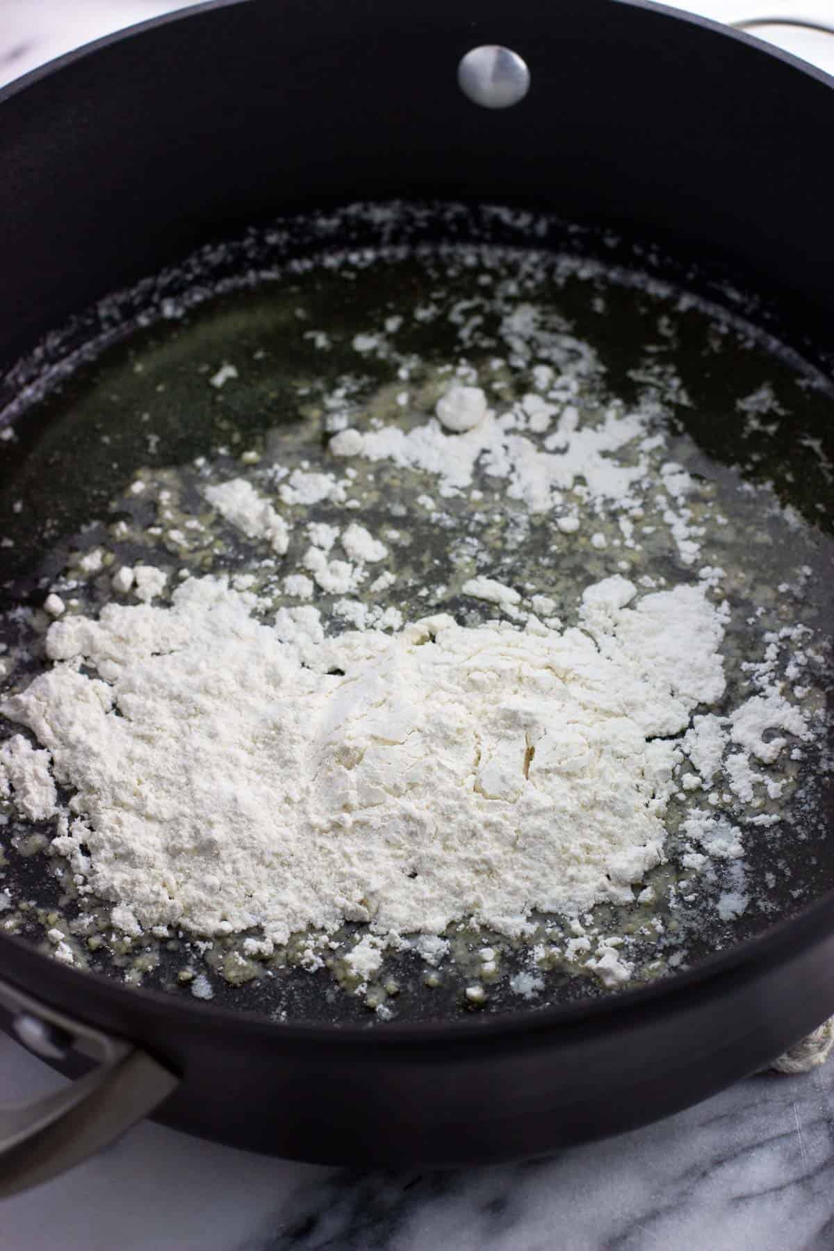 Flour added to a pan of melted butter.