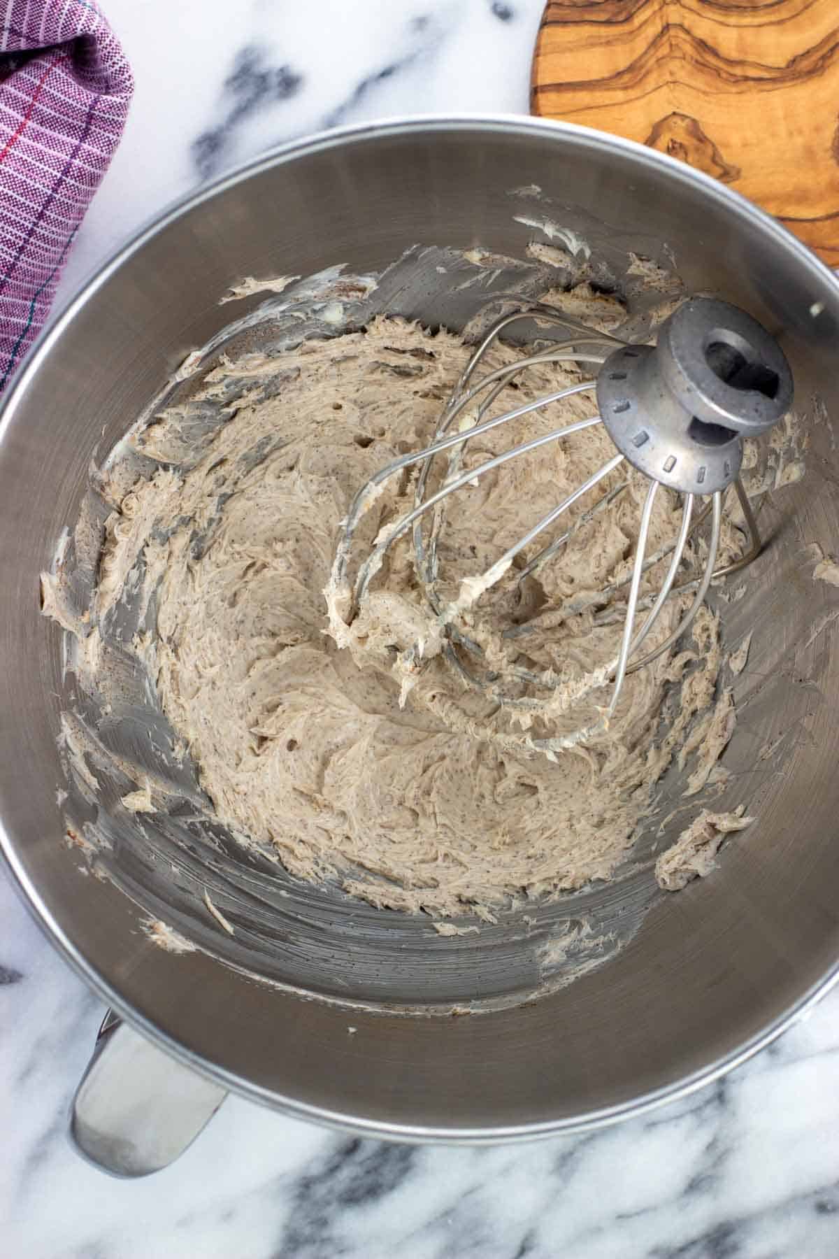 Whipped butter and spices in the bowl of a food processor with the whisk attachment.