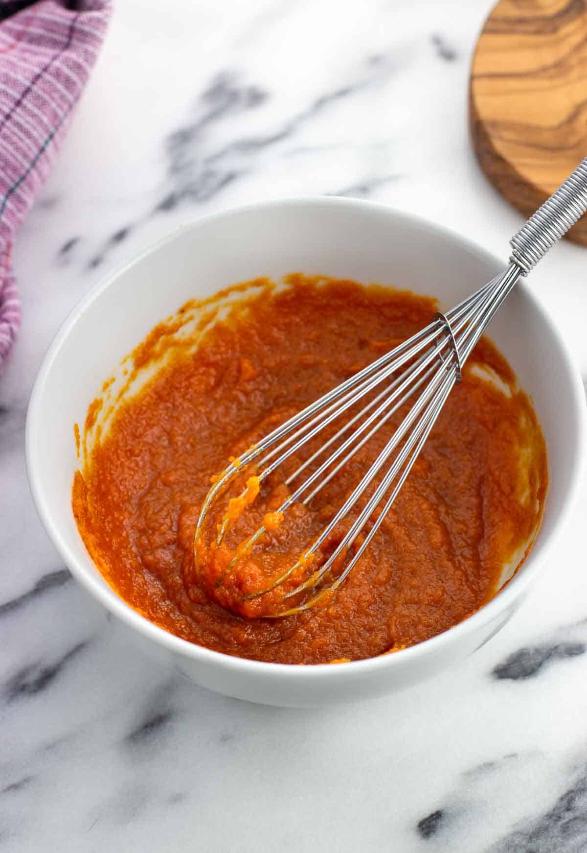 Pumpkin puree and honey whisked together in a bowl.