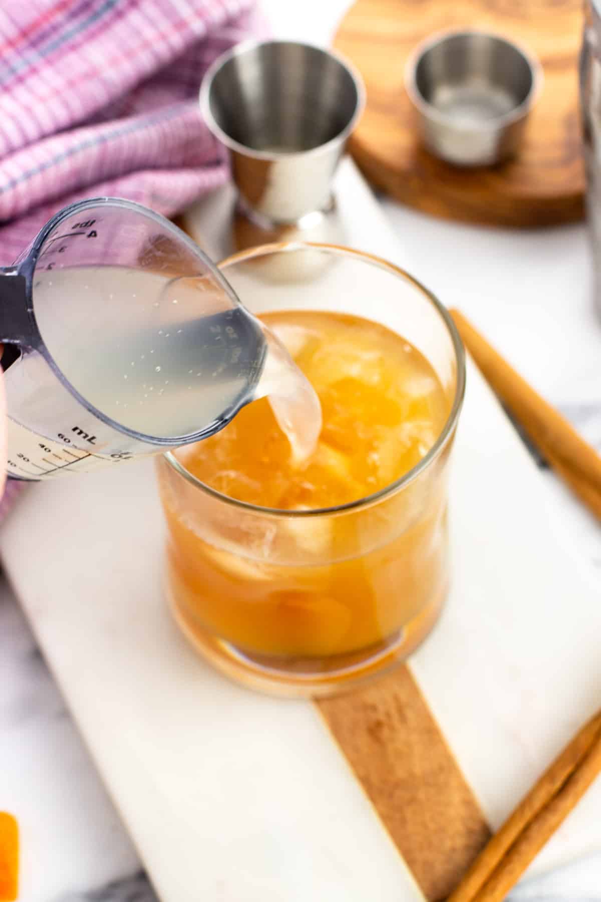 Ginger beer being poured into the cocktail glass.