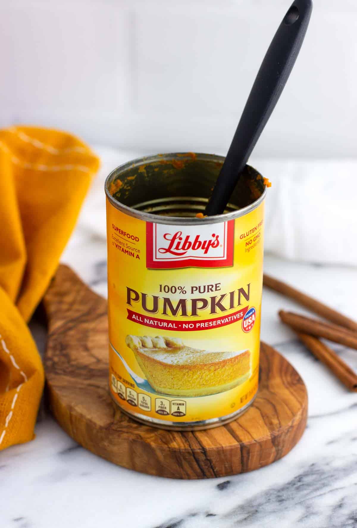 An empty can of pumpkin puree with a small spatula in it.