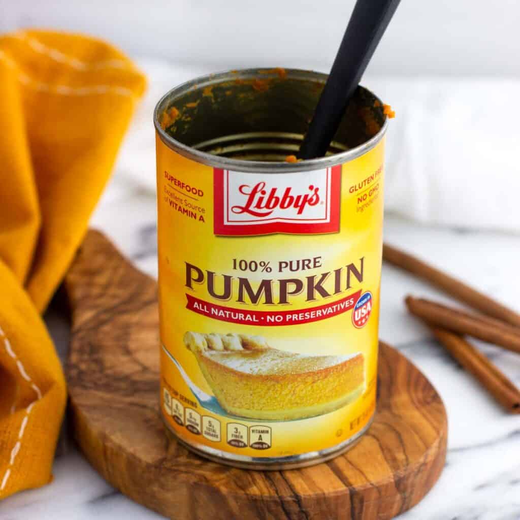 An empty can of pumpkin puree with a small spatula in it.