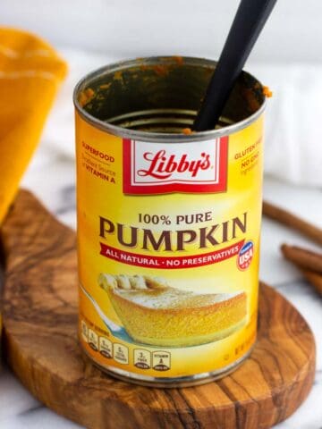 An empty can of pumpkin puree with a small spatula in it.