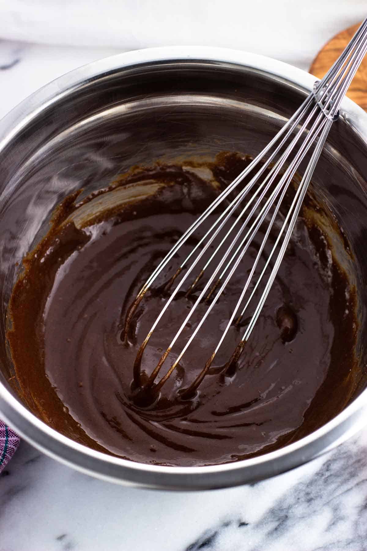 Whisked together brownie wet ingredients in a bowl.