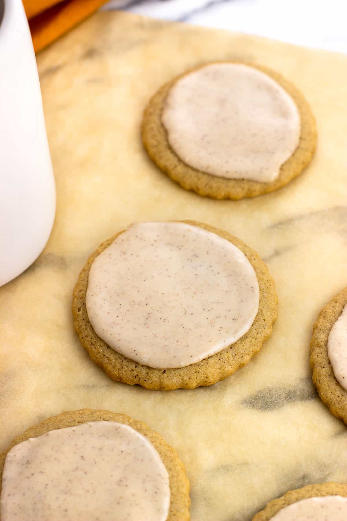 Iced cookies on a sheet of parchment.