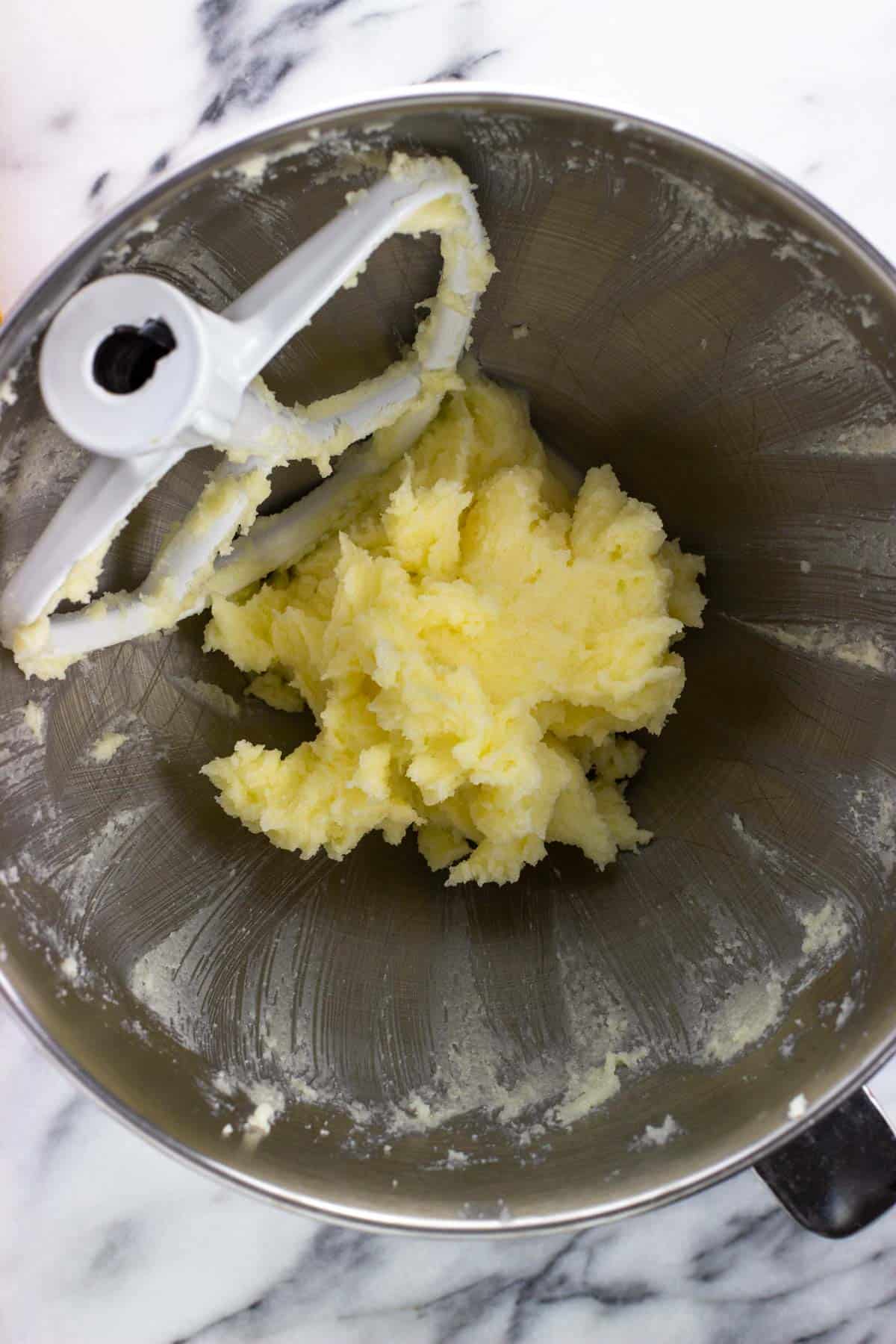 Butter and sugar creamed together in a mixing bowl.