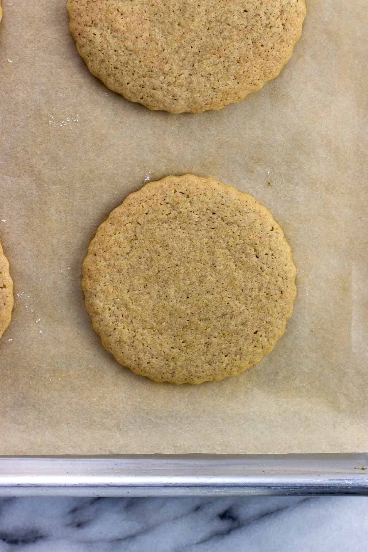 Baked maple cinnamon sugar cookies on a parchment-lined pan.