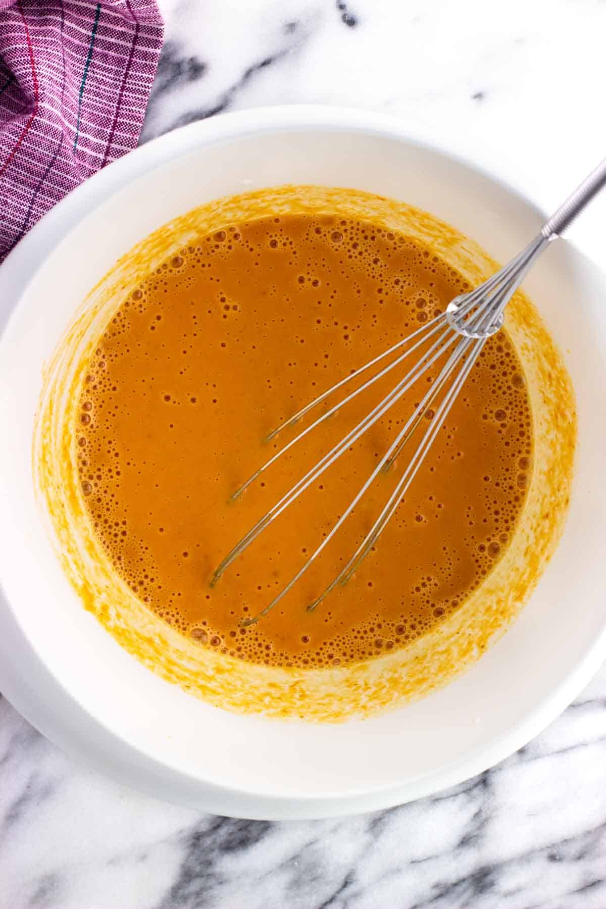 Wet ingredients whisked together smoothly in the mixing bowl.