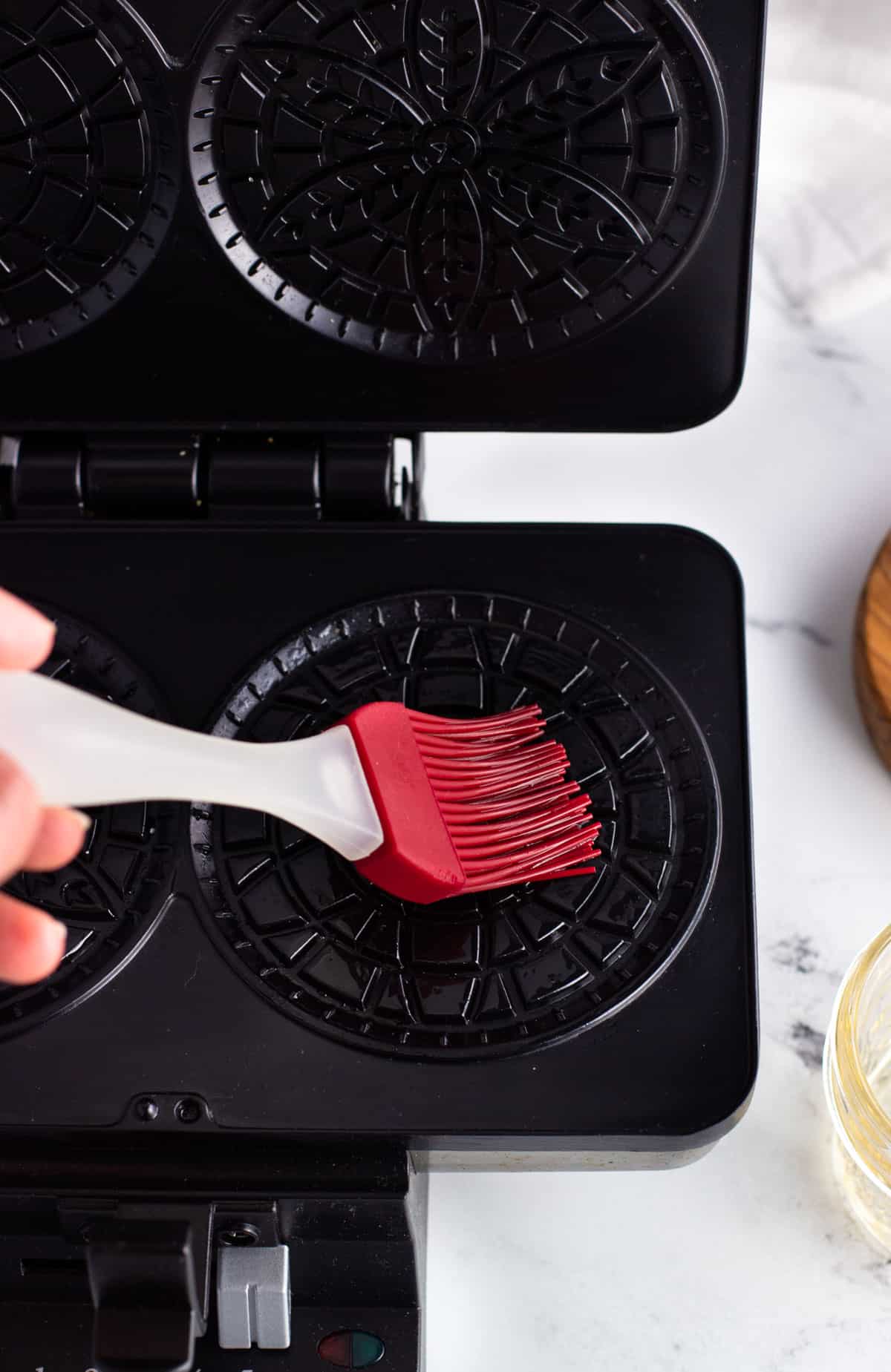 Brushing oil onto the pizzelle press.