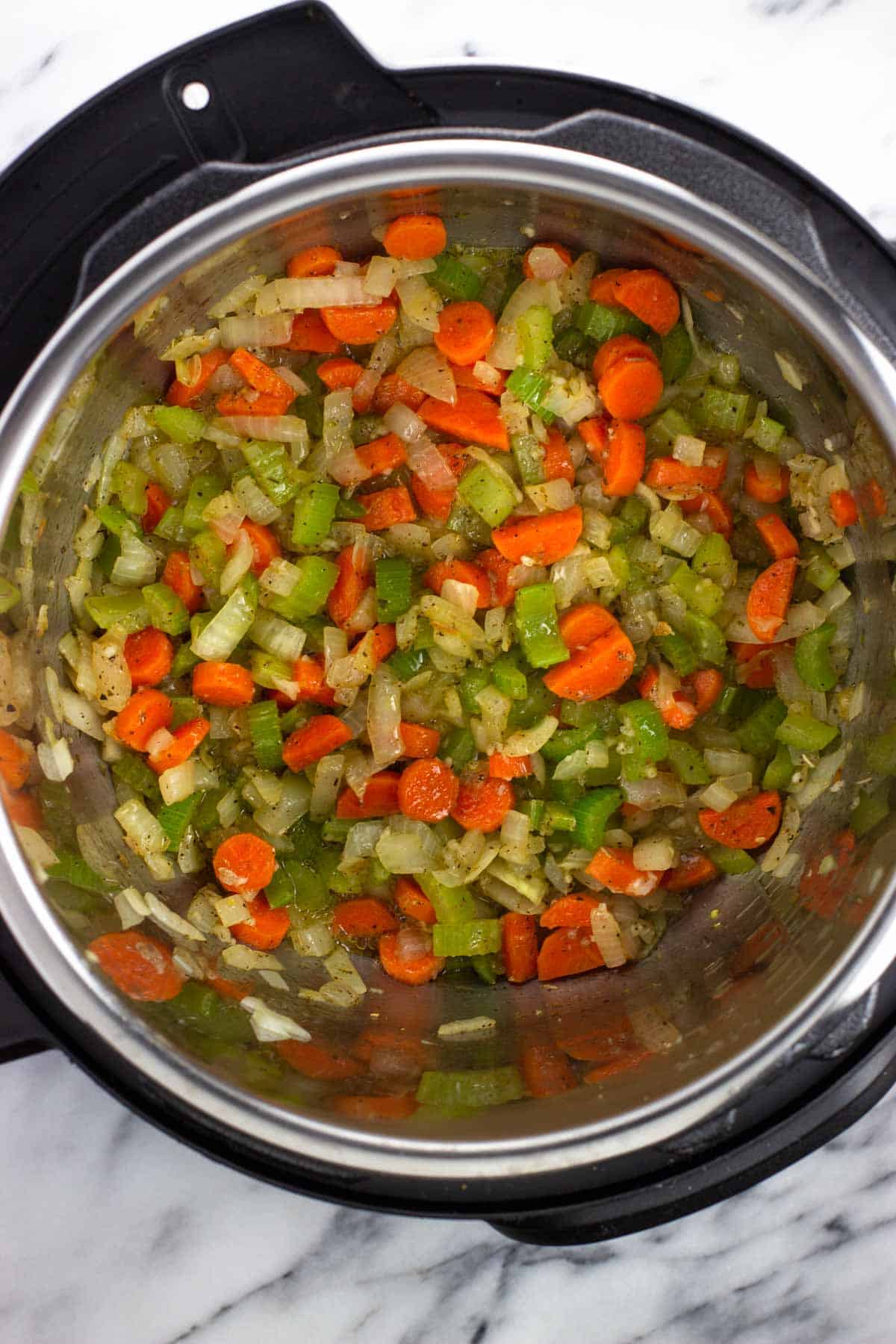 Onion, carrots, celery, garlic, and spices in the Instant Pot.