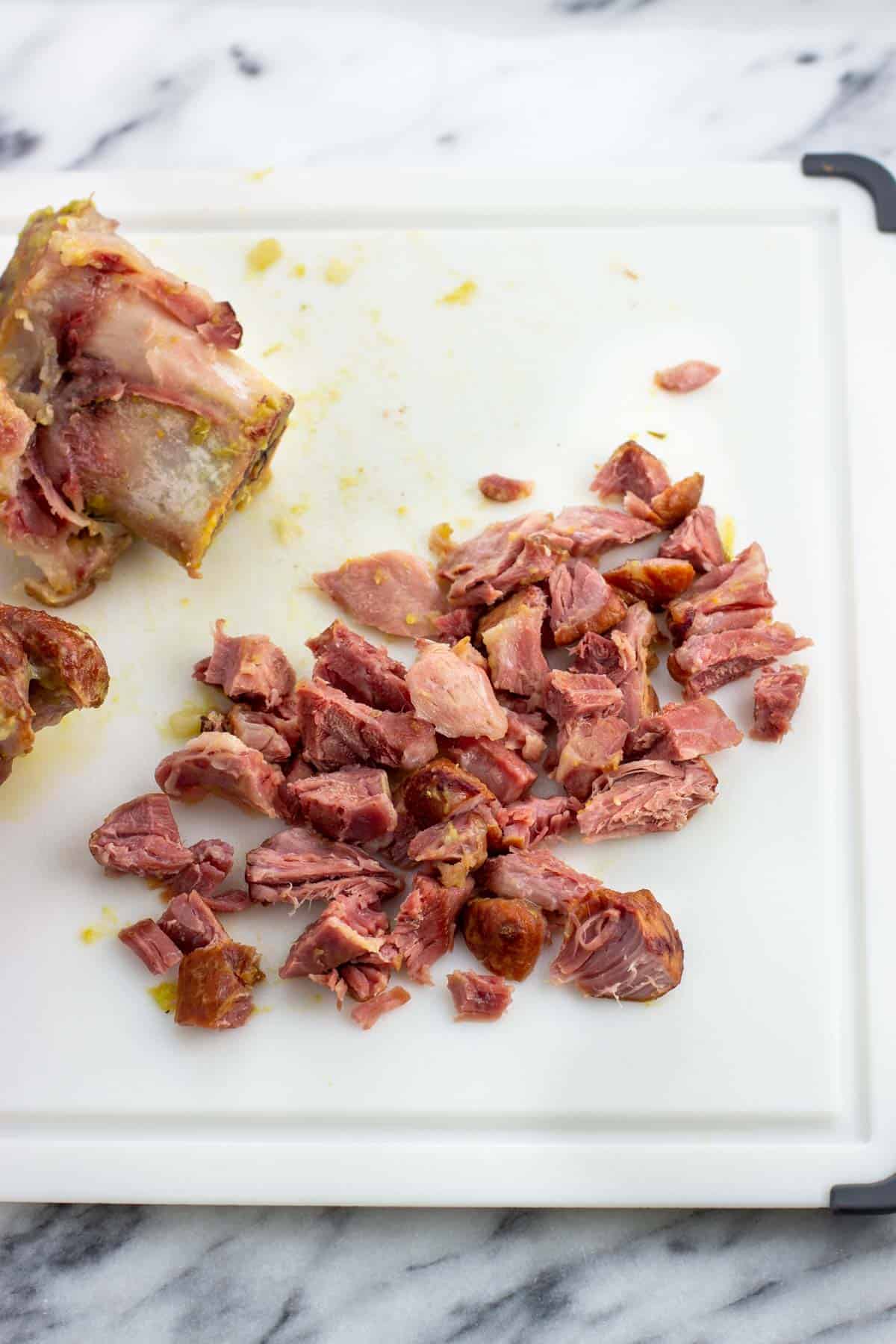 Shredded ham hocks on a cutting board.