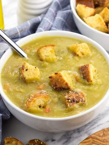 A bowl of split pea soup topped with croutons.