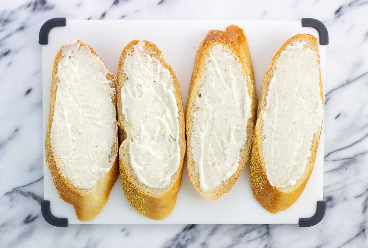 Four slices of bread covered in horseradish aioli.