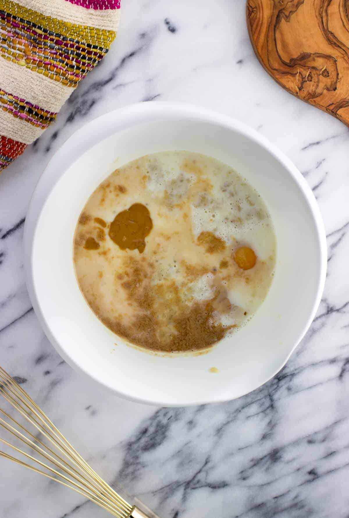 All wet ingredients added to the bowl with mashed banana.