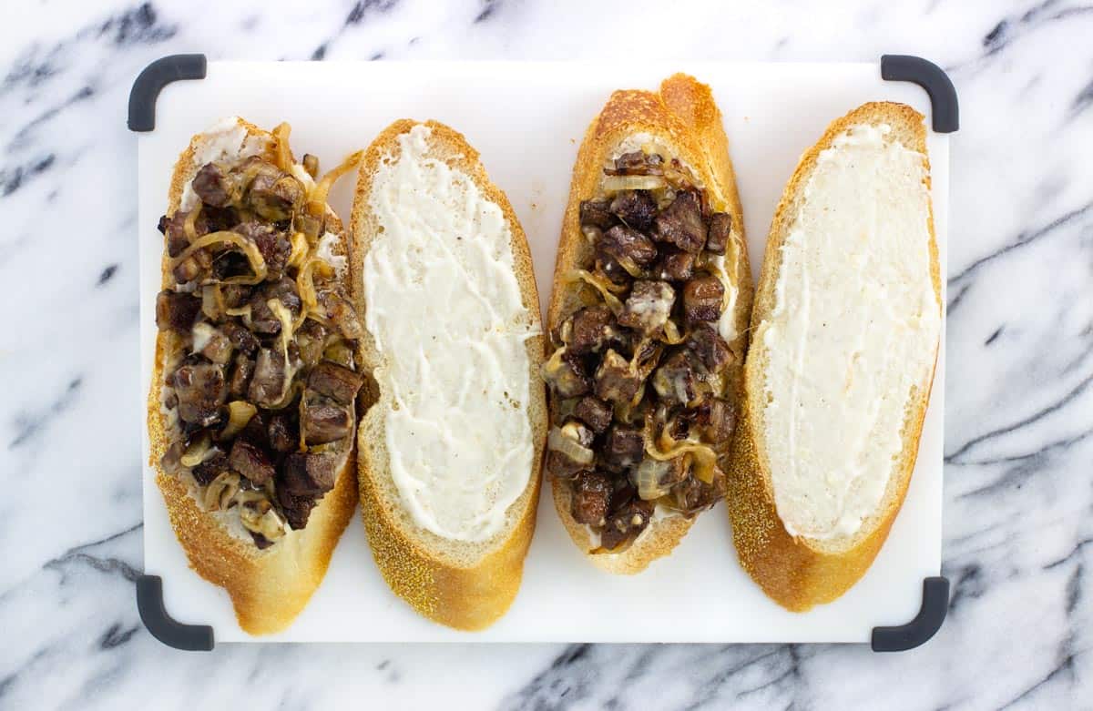 Two open face sandwiches with aioli and the steak/onion mixture.