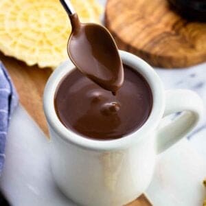 A coated spoon lifting out of the mug of thick cioccolata calda.